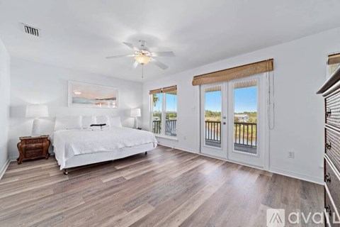 A bedroom with a large bed and a balcony.