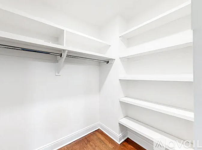 A white wall with a wooden floor and a white shelf.
