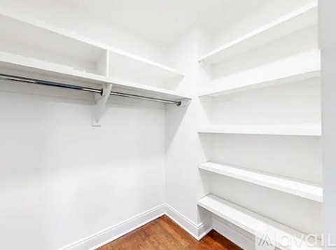 A white wall with a wooden floor and a white shelf.
