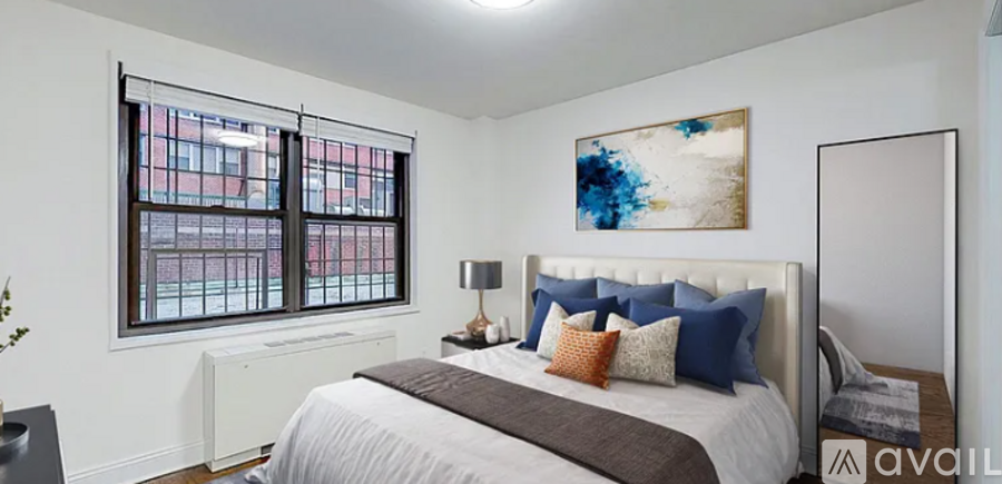A bedroom with a large bed and a painting on the wall.