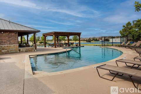 A pool area with sun loungers and a pavilion.