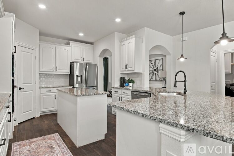 A kitchen with white cabinets and a granite countertop.