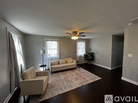 A living room with a rug, two chairs, and a sofa.