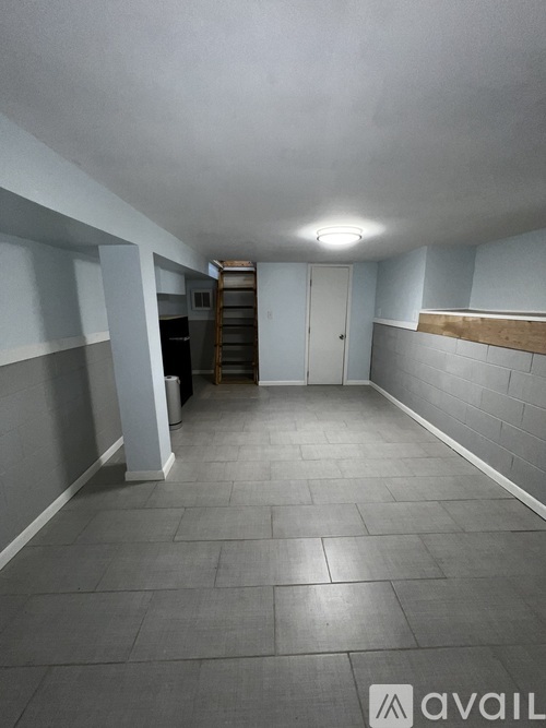A long hallway with a light on the ceiling and a staircase on the right.