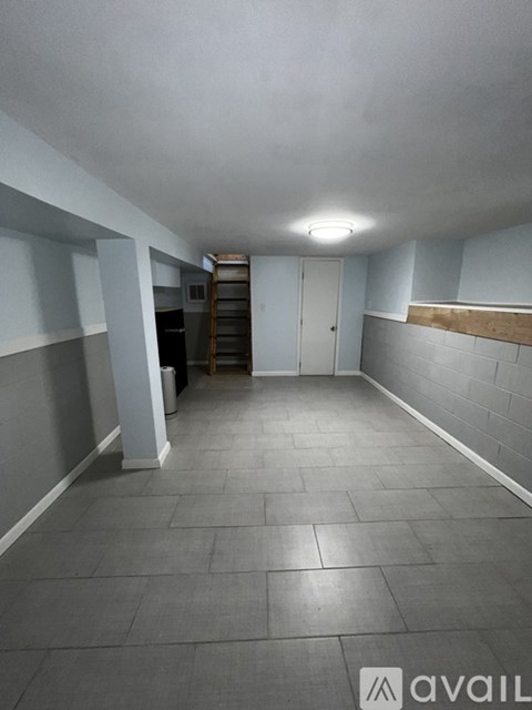 A long hallway with a light on the ceiling and a staircase on the right.