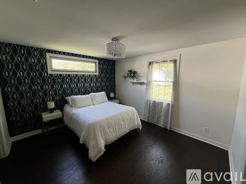 A bedroom with a patterned wallpaper and a large bed.
