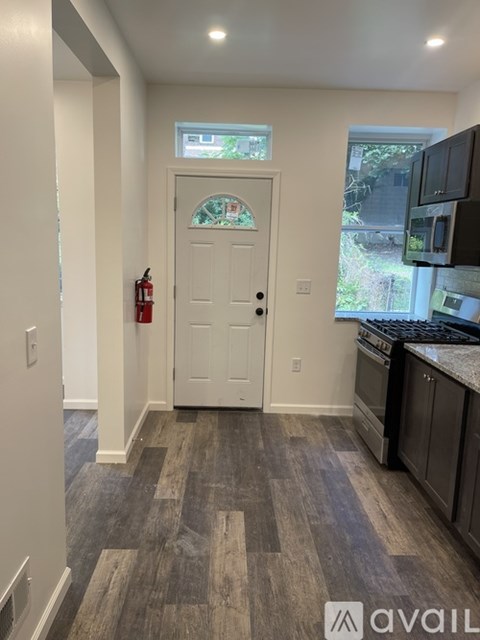 A kitchen with a white door and a fire extinguisher on the wall.