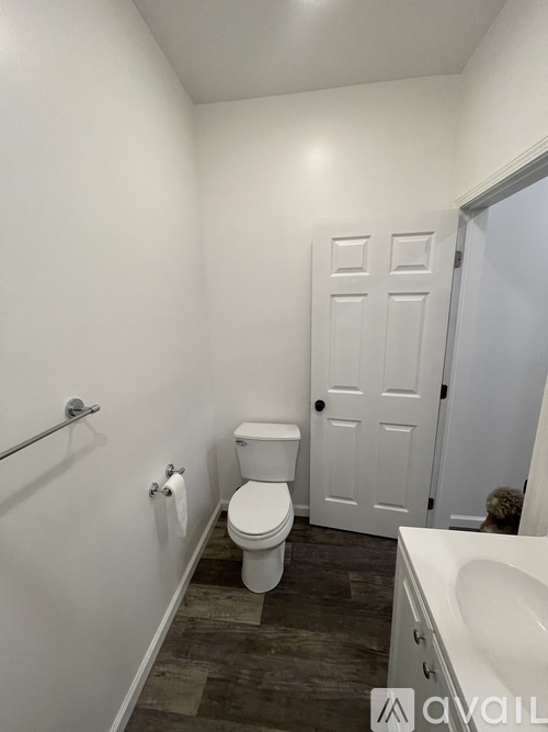A bathroom with a toilet, sink, and a door.
