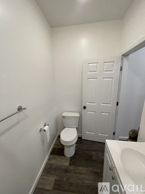 A bathroom with a toilet, sink, and a door.