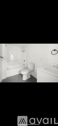 A bathroom with a toilet, sink, and mirror.
