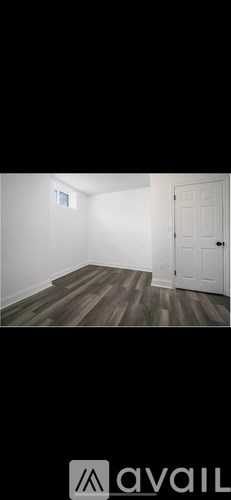 A room with wooden flooring and a white door.