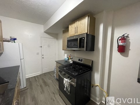 A kitchen with a black stove top oven and a black microwave above it.