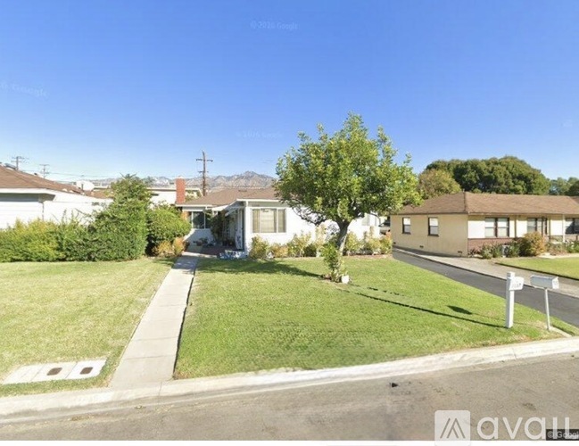 A house with a white fence is for sale.