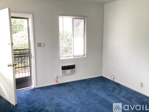 A room with a door, window, and a wall socket.