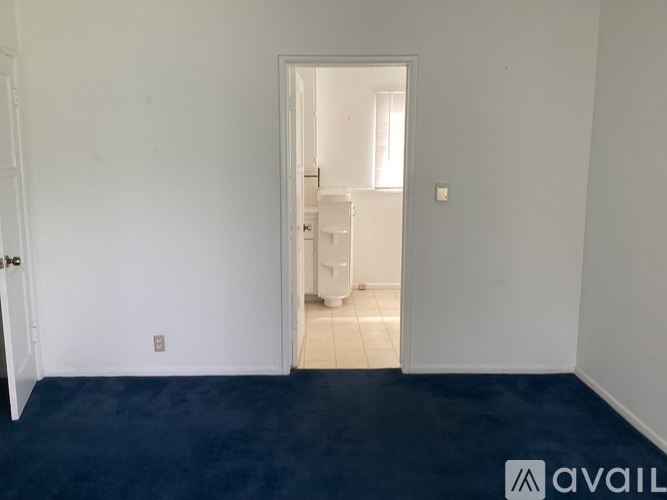 A room with a carpeted floor and a doorway leading to another room.