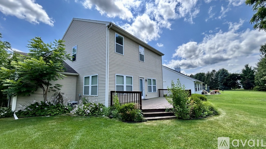 A house with a deck and a lawn in front.