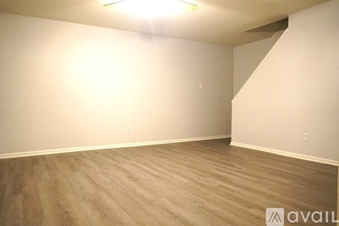 A room with wooden flooring and white walls.
