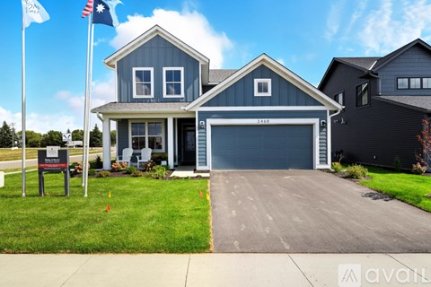 A house with a garage and a sign in front of it.