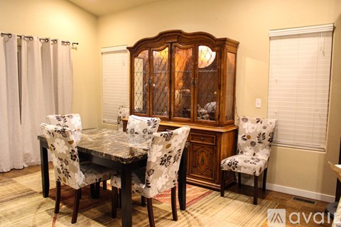 A dining room with a table and chairs.