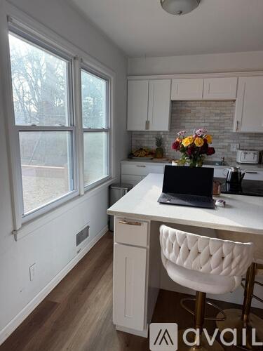 A kitchen with a laptop on the counter.