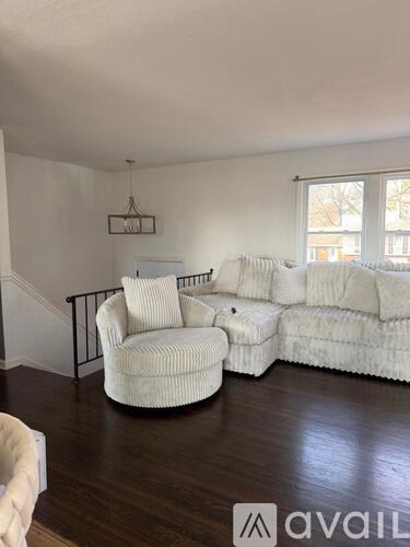 A living room with a white couch and a white chair.