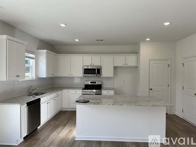 A modern kitchen with white cabinets and a central island.