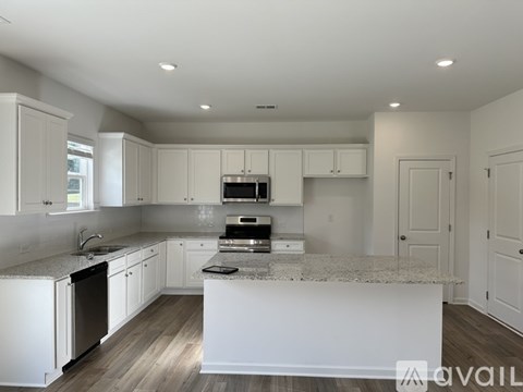 A modern kitchen with white cabinets and a central island.