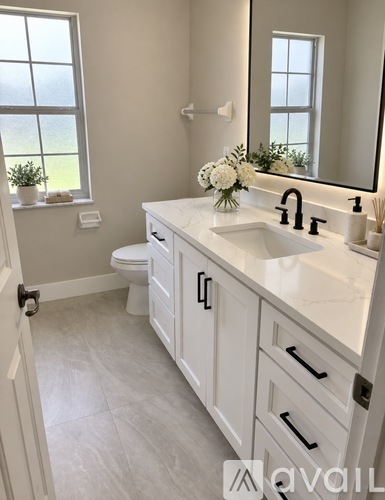 A bathroom with a white sink and a white toilet.
