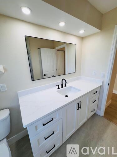 A bathroom with a sink, mirror and toilet.