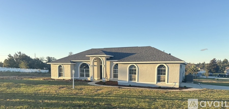 A house with a grey roof and beige walls is available for sale.