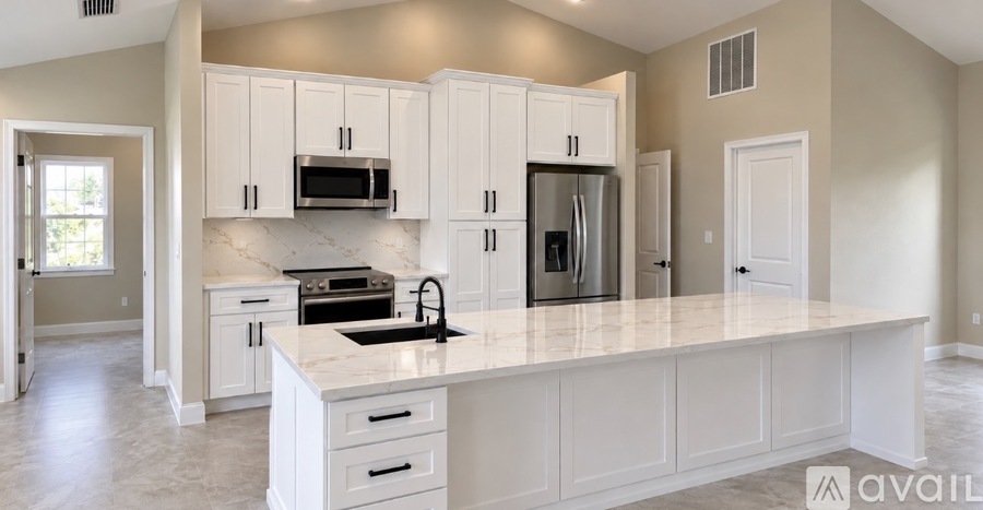 A kitchen with white cabinets and appliances.