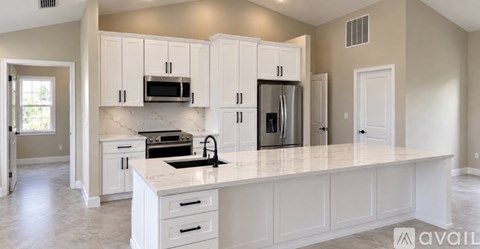 A kitchen with white cabinets and appliances.