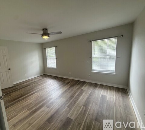 A room with wooden flooring and a ceiling fan.