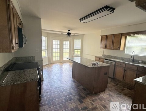 A kitchen with a tile floor and wooden cabinets.