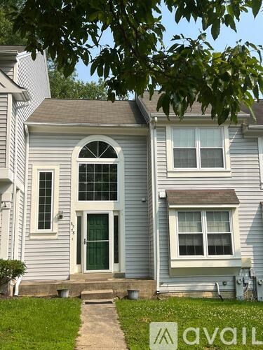 A house with a green door and a window is for sale.