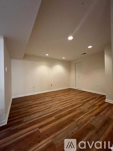A room with wooden flooring and white walls.