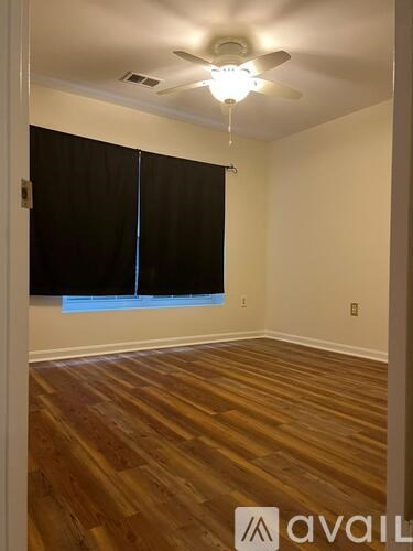 A room with wooden floors and a ceiling fan.