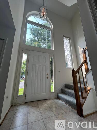 A white door with a glass window is in a hallway with a tiled floor.
