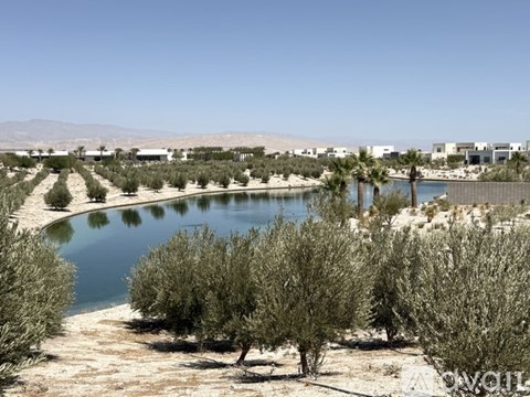 A body of water surrounded by greenery and buildings in the distance.