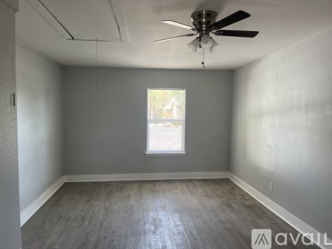 A room with a ceiling fan and a window.