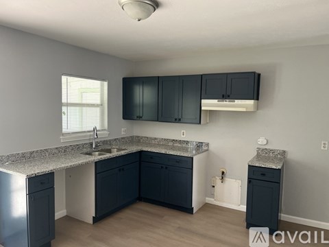 A kitchen with dark cabinets and granite countertops.