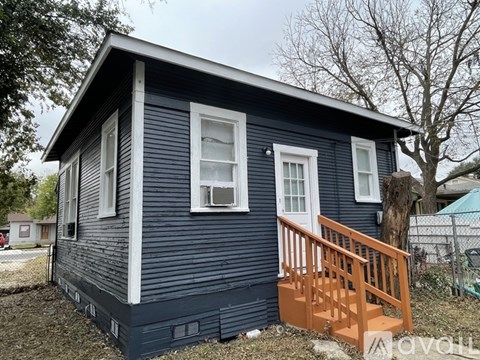 A small blue house with a white door and windows.