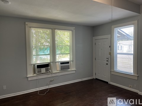 A room with a window and a door is available for rent.