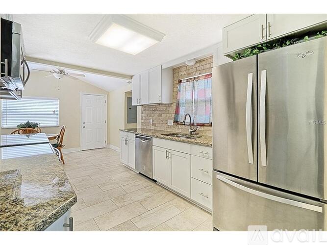 A kitchen with a refrigerator, cabinets, and a countertop.