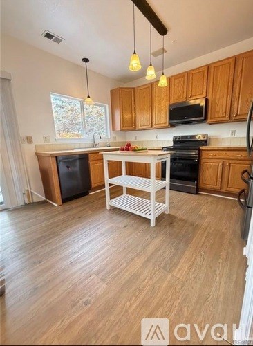 A kitchen with wooden cabinets and a white island.
