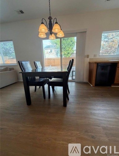 A dining room with a table and chairs.
