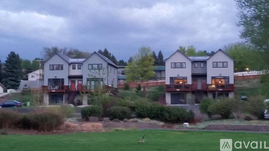 A row of houses with a grassy area in front.