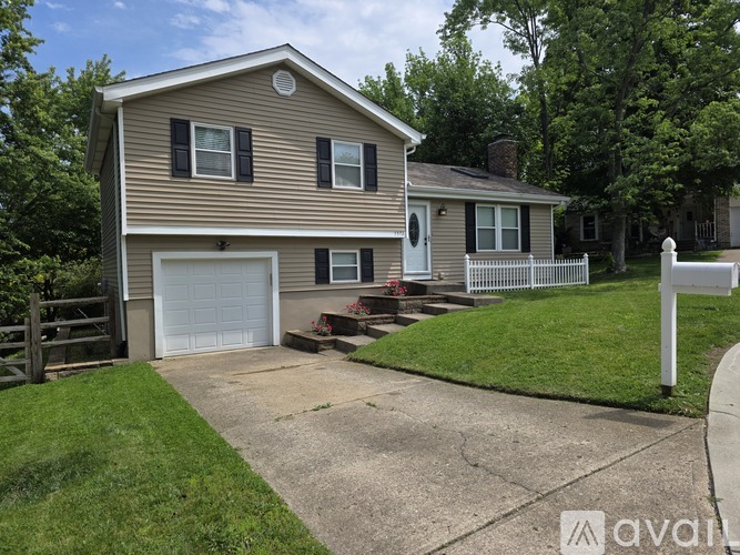 A house with a garage and a white fence in front.