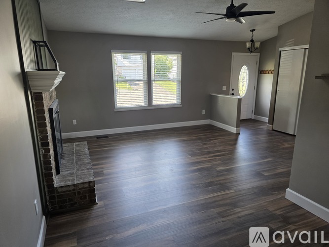 A living room with a fireplace and wood flooring.