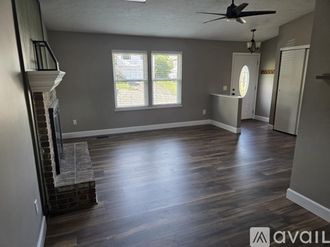 A living room with a fireplace and wood flooring.